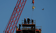 Photo d'une grue qui a hissé un nouveau coq en cuivre au sommet de la flèche flambant neuve de la cathédrale Notre-Dame de Paris