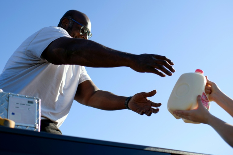 Un habitant reçoit du lait lors d'une distribution d'aide alimentaire à Houston, au Texas, le 1er novembre 2025 ( AFP / Mark Felix )