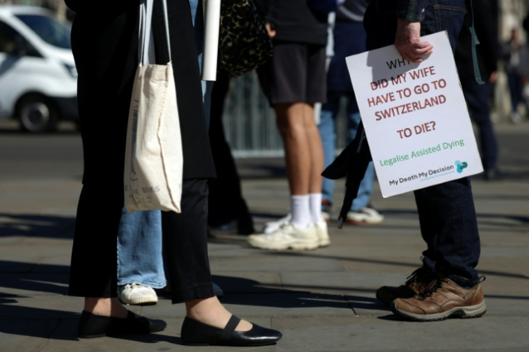 Des militants en faveur d'une modification de la loi sur l'aide médicale à mourir, rassemblés devant le palais de Westminster,le 24 avril 2026 à Londres ( AFP / Toby Shepheard )