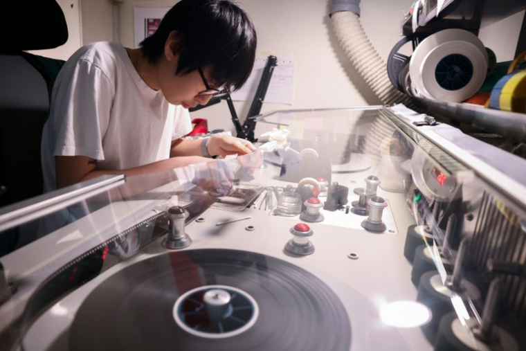 Un technicien répare la pellicule d'un vieux film à l'Institut taïwanais du cinéma et de l'audiovisuel (TFAI), le 23 juin 2026 à Taipeï ( AFP / I-Hwa Cheng )
