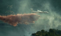 Un avion de lutte contre les incendies largue des produits ignifuges sur des arbres lors d'un incendie de forêt près de Fontcouverte, dans l'Aude, le 5 juillet 2025 ( AFP / IDRISS BIGOU-GILLES )
