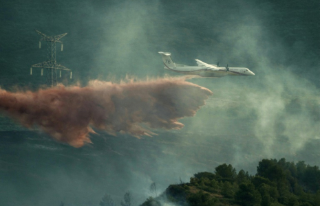 Un avion de lutte contre les incendies largue des produits ignifuges sur des arbres lors d'un incendie de forêt près de Fontcouverte, dans l'Aude, le 5 juillet 2025 ( AFP / IDRISS BIGOU-GILLES )