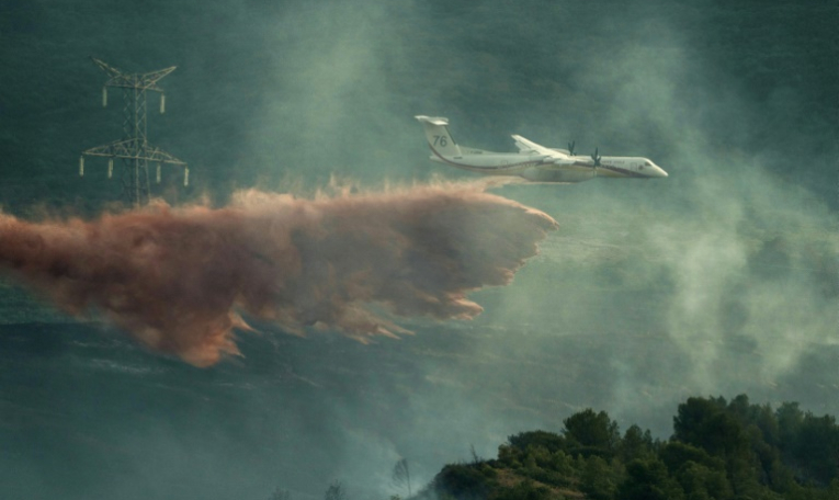Un avion de lutte contre les incendies largue des produits ignifuges sur des arbres lors d'un incendie de forêt près de Fontcouverte, dans l'Aude, le 5 juillet 2025 ( AFP / IDRISS BIGOU-GILLES )