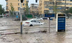 L'eau jaillit dans une rue inondée à la suite du typhon Doksuri à Pékin.