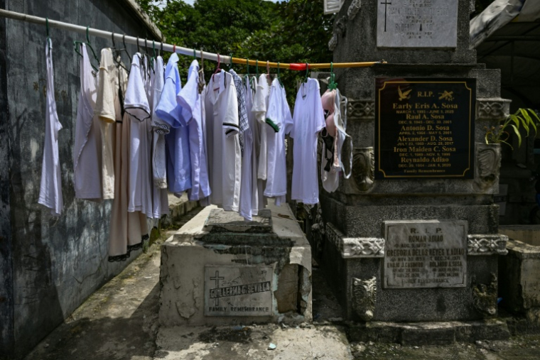 Des vêtements sèchent sur un étendoir posé entre une tombe et un mur au cimetière nord de Manille, aux Philippines, le 21 octobre 2025 ( AFP / Jam STA ROSA )
