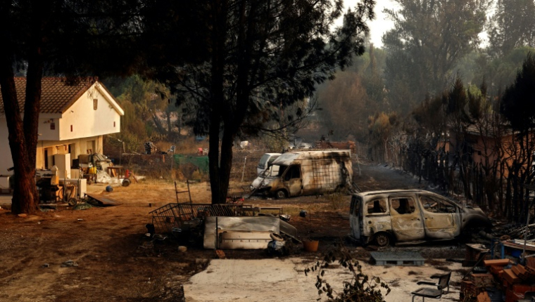 Des carcasses de voitures calcinées dans une propriété après un incendie de forêt à Pelayos de la Presa, à environ 65 km à l'ouest de Madrid, le 26 juillet 2026  ( AFP / Oscar DEL POZO )
