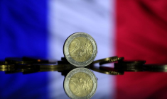 Des pièces en euros sont visibles devant le drapeau français sur cette photo.
