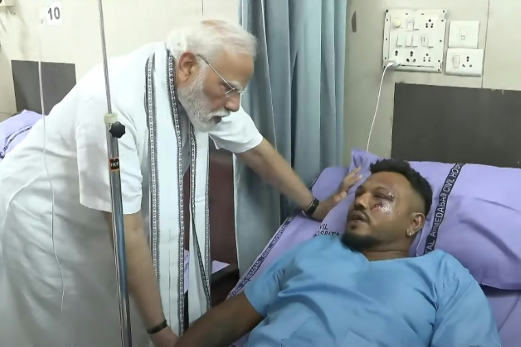 Image tirée d'une vidéo prise et publiée par la chaîne YouTube Narendra Modi, le 13 juin 2025, montrant le Premier ministre indien Narendra Modi (g) rencontrant Vishwash Kumar Ramesh, seul survivant du crash du vol 171 d'Air India, dans un hôpital à Ahmedabad ( NARENDRA MODI YOUTUBE CHANNEL / - )
