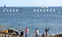 Des voiliers école naviguent en formation pour rendre hommage à Charlie Dalin, dans le cadre de la journée consacrée à la mémoire du navigateur décédé en juin, mardi à Concarneau. ( AFP / FRED TANNEAU )