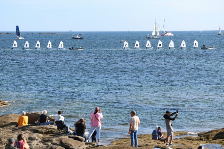Des voiliers école naviguent en formation pour rendre hommage à Charlie Dalin, dans le cadre de la journée consacrée à la mémoire du navigateur décédé en juin, mardi à Concarneau. ( AFP / FRED TANNEAU )