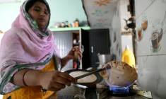 L'agricultrice Gauri Devi cuisine sur un réchaud alimenté par du biogaz issu de bouses de vache, à son domicile dans le district de Bulandshahr, dans l'Uttar Pradesh, le 24 avril 2026 en Inde ( AFP / Arun SANKAR )