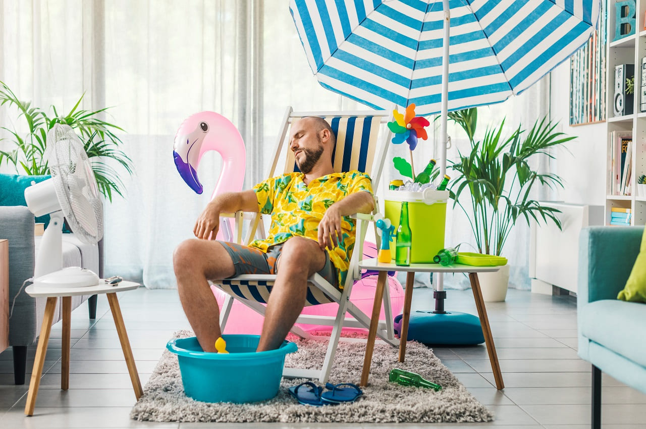 (Homme installé chez lui dans une ambiance vacances - Crédit photo : Adobe Stock)
