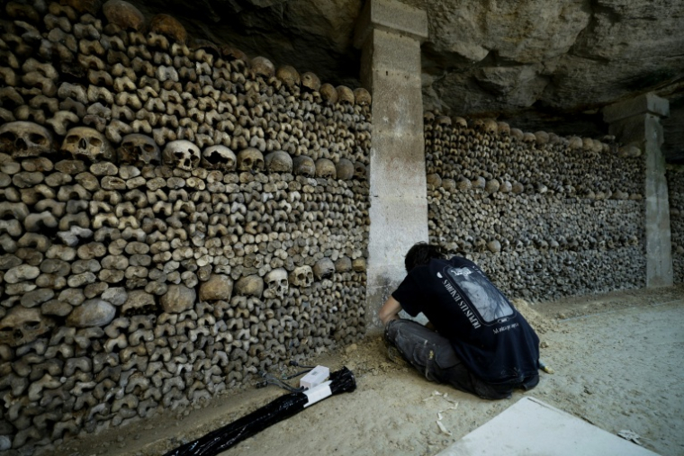 Un électricien travaille sur le chantier de restauration des Catacombes de Paris, le 24 mars 2026 ( AFP / Kenzo TRIBOUILLARD )