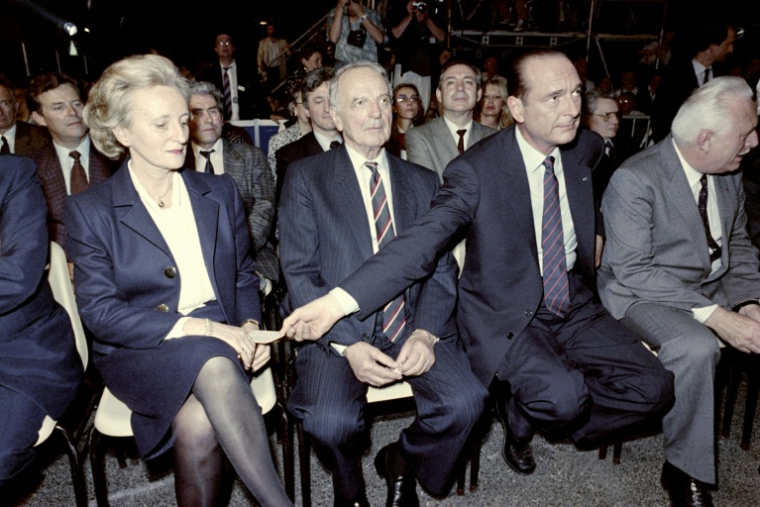 Le Premier ministre et candidat à la présidentielle Jacques Chirac (D) fait passer un mot à son épouse Bernadette lors d'un meeting de campagne, le 6 mai 1988 à  Aulnat, dans le Puy-de-Dôme  ( AFP / Pascal PAVANI )