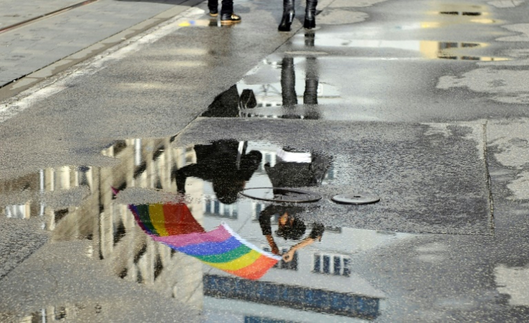 Un drapeau LGBT+ se reflète sur le trottoir mouillé d'une rue de Bratislava en Slovaquie, durant la marche des fiertés, le 21 septembre 2013. ( AFP / SAMUEL KUBANI )