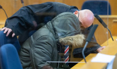 Alaa Moussa (G), un médecin syrien accusé de crimes contre l'humanité, parle avec son avocat à l'ouverture de son procès, le 19 janvier 2022 à Francfort ( POOL / Boris Roessler )