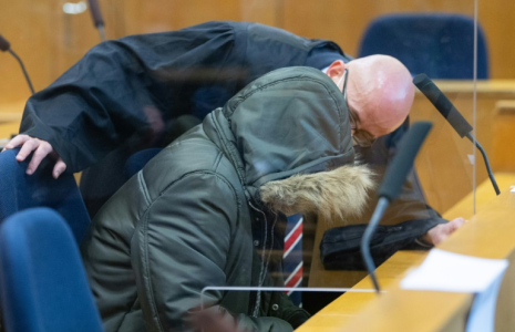 Alaa Moussa (G), un médecin syrien accusé de crimes contre l'humanité, parle avec son avocat à l'ouverture de son procès, le 19 janvier 2022 à Francfort ( POOL / Boris Roessler )