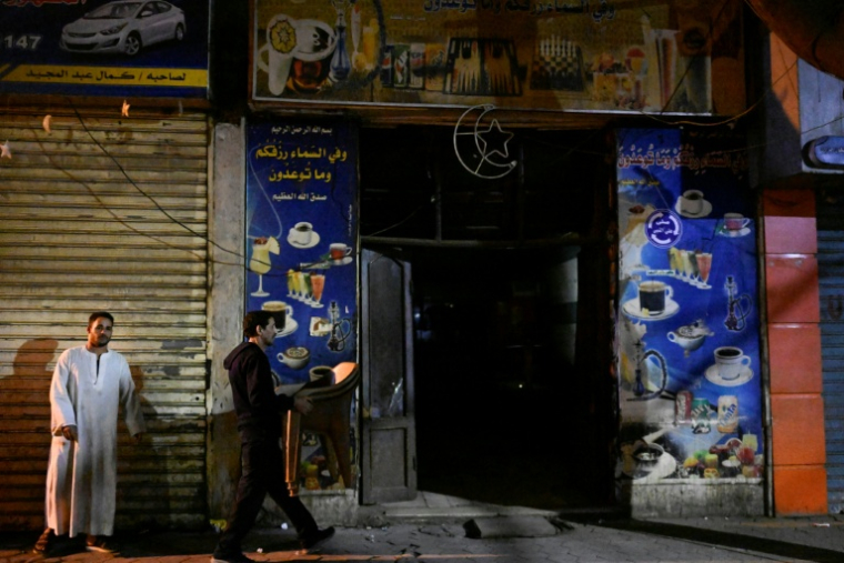 Un serveur enlève une table avant la fermeture d'un commerce en application du couvre-feu, dans le centre-ville du Caire, le 2 avril 2026 en Egypte ( AFP / Khaled DESOUKI )