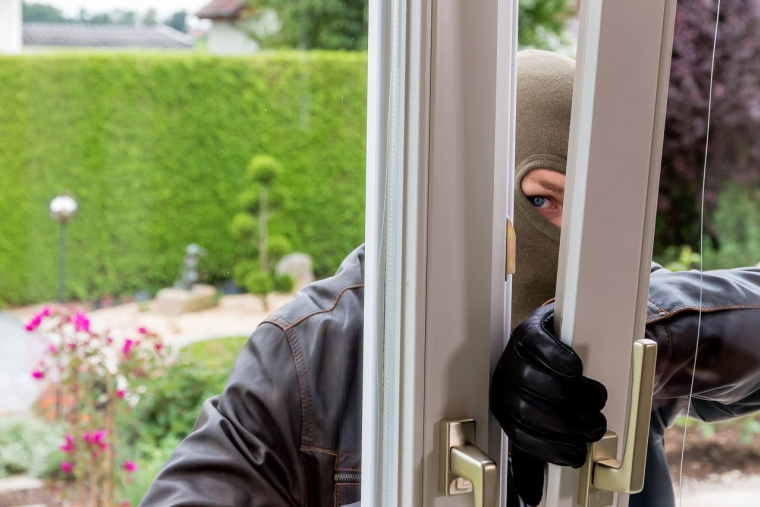 (Crédits photo : Adobe Stock - Homme cagoulé tentant une intrusion dans une maison par une porte-fenêtre)