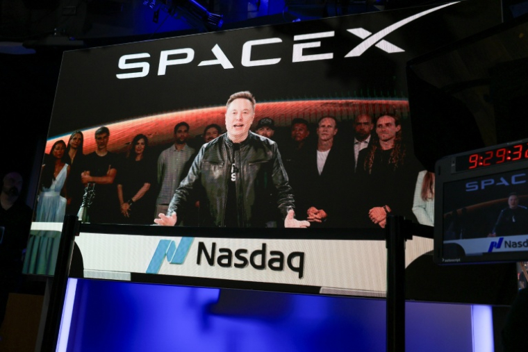 Un écran situé à New York retransmet la prise de parole d'Elon Musk à Starbase, Texas, le 12 juin 2026 ( AFP / TIMOTHY A. CLARY )