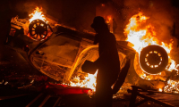 Une voiture est incendiée lors d'une manifestation à Yogyakarta, le 29 août 2025 en Indonésie, après la mort d'un chauffeur de taxi-moto, écrasé par un véhicule des forces de l'ordre ( AFP / Devi RAHMAN )