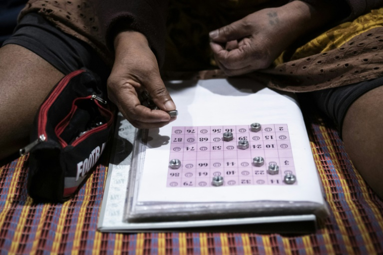 Une participante joue au bingo sur le parking d'un centre commercial désaffecté, dans le quartier de Rivière-Salée à Nouméa, en Nouvelle-Calédonie, le 8 mai 2025 ( AFP / Delphine MAYEUR )