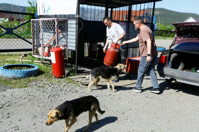 Iaroslav Voronov, vendeur dans un magasin d'électroménager, fait remplir une bouteille de gaz dans une station-service à Chtchoutchinsk, le 27 mai 2026 au Kazakhstan ( AFP / Ruslan PRYANIKOV )