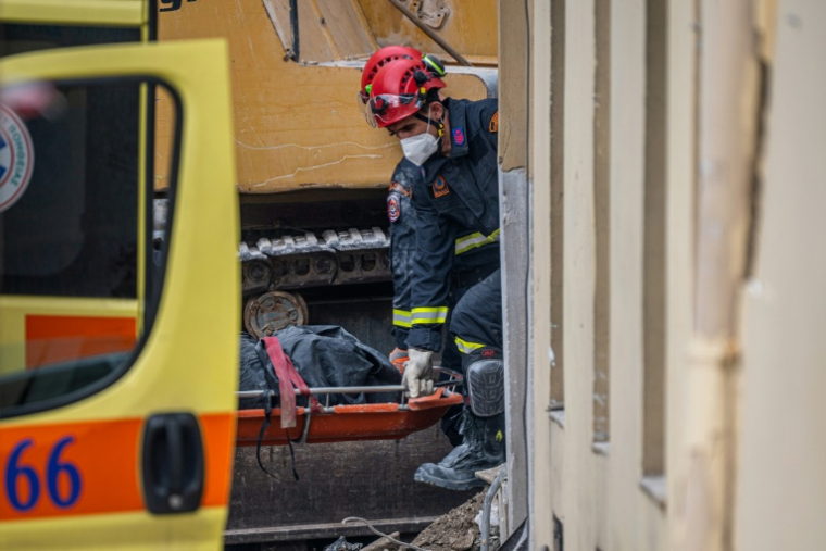 Des secouristes transportent le corps d'une personne retrouvée sous les décombres après l'effondrement d'un immeuble à Athènes, le 26 septembre 2026  ( AFP / Angelos TZORTZINIS )