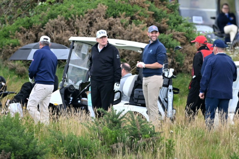 Donald Trump (2eG) et son fils Eric (C) sur le parcours de Golf de Turnberry en Ecosse, le 26 juillet 2025 ( AFP / ANDY BUCHANAN )