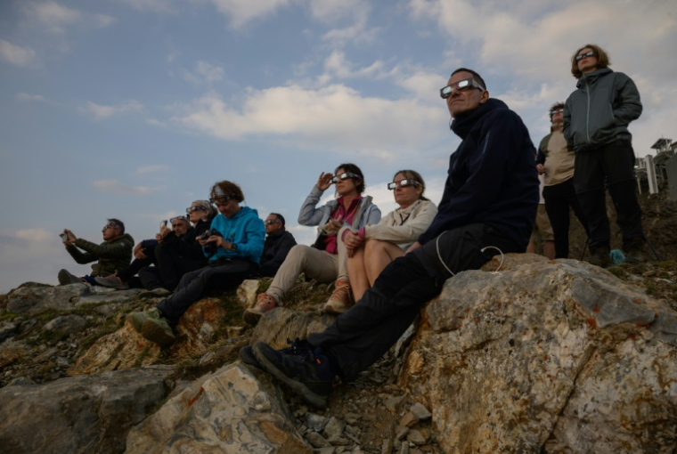 Des personnes observent la Lune passer devant le disque solaire lors d'une éclipse partielle, au sommet du Pic du Midi, le 12 août 2026 ( AFP / Ed JONES )