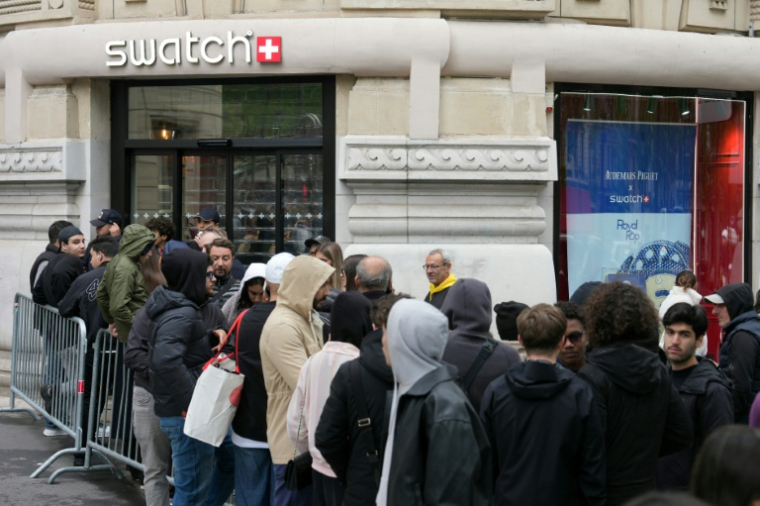 Des personnes font la queue devant une boutique Swatch fermée pour la sortie de la montre Audemars Piguet Swatch "Royal Pop", le 16 mai 2026 à Paris  ( AFP / Dimitar DILKOFF )
