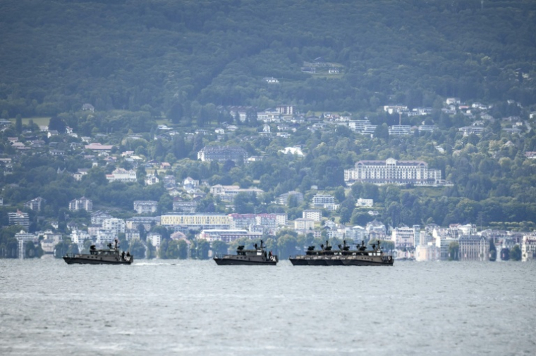 Des bateaux militaires suisses patrouillent sur le lac Léman au large de la ville d'Évian-les-Bains, avec l'Hôtel Royal (d) en arrière-plan, le 10 juin 2026 à Lausanne, en Suisse ( AFP / Fabrice COFFRINI )