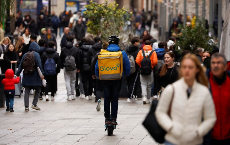 Un livreur Glovo passe dans une zone piétonne à Barcelone
