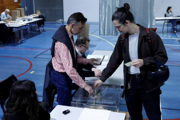 Un électeur vote au second tour des municipales, le 22 mars 2026 à Paris  ( AFP / Kenzo TRIBOUILLARD )