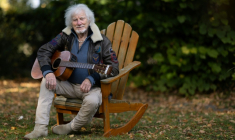 Le chanteur Hugues Aufray, 96 ans, joue de la guitare dans le jardin de sa maison à Marly-le-Roi, dans les Yvelines, le 14 octobre 2025 ( AFP / JOEL SAGET )