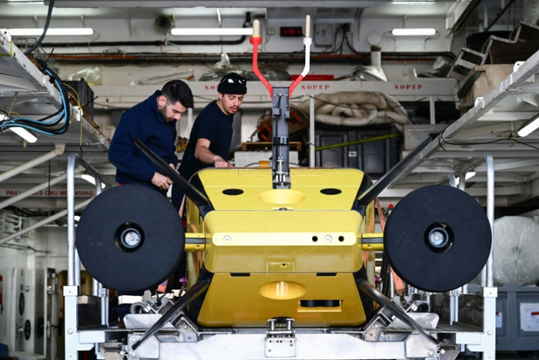 Des techniciens préparent le robot sous-marin Ulyx à bord du navire scientifique L'Atalante, amarré au port de Brest, le 15 juin 2025 ( AFP / Sebastien Salom-Gomis )