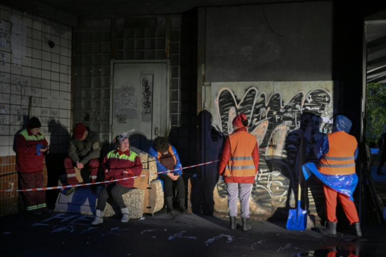 Des employés municipaux devant un immeuble résidentiel endommagé par des frappes massives de drones et de missiles russes à Kiev, le 10 octobre 2025 ( AFP / Genya SAVILOV )