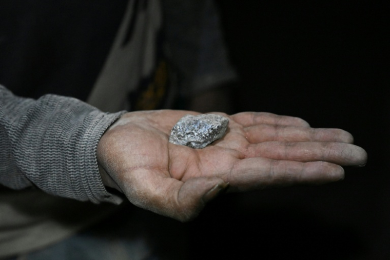 Un mineur montre un morceau d'argent dans la mine de Cerro Rico, à Potosi, en Bolivie, le 19 février 2026 ( AFP / Aizar RALDES )