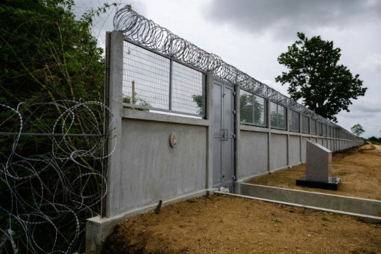Un mur en béton surmonté de barbelés, érigé par l'armée thaïlandaise, le long de la frontière entre la Thaïlande et le Cambodge, dans le district de Pong Nam Ron, dans la province de Chanthaburi, le 10 septembre 2026 en Thaïlande ( AFP / ANTHONY WALLACE )