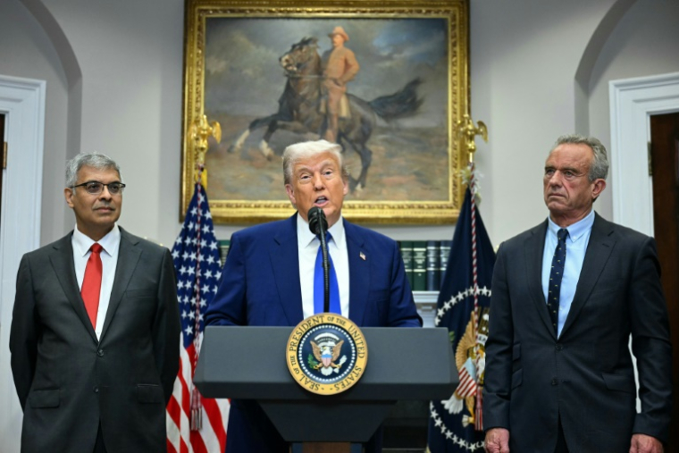 Le président américain Donald Trump entouré du ministre américain de la Santé Robert F. Kennedy Jr. (droite) et de Jayanta Bhattacharya (gauche), directeur de l'organisme chargé de la recherche médicale (NIH) à la Maison Blanche, le 12 mai 2025 ( AFP / Jim WATSON )