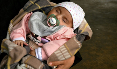 Une femme tient son bébé dans un couloir d’une école transformée en centre d’accueil pour personnes déplacées, dans la région de Dekwaneh, à l’est de Beyrouth, le 15 avril 2026 ( AFP / Joseph EID )