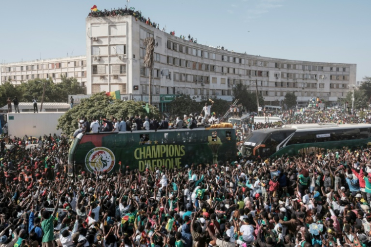 Des supporters de l'équipe de football sénégalaise célèbrent le 20 janvier 2026 leur victoire lors de la finale de la CAN-2025 face au Maroc. Les Lions de la Teranga ont défilé lors d'une grande parade populaire à travers les rues de Dakar  ( AFP / GUY PETERSON )