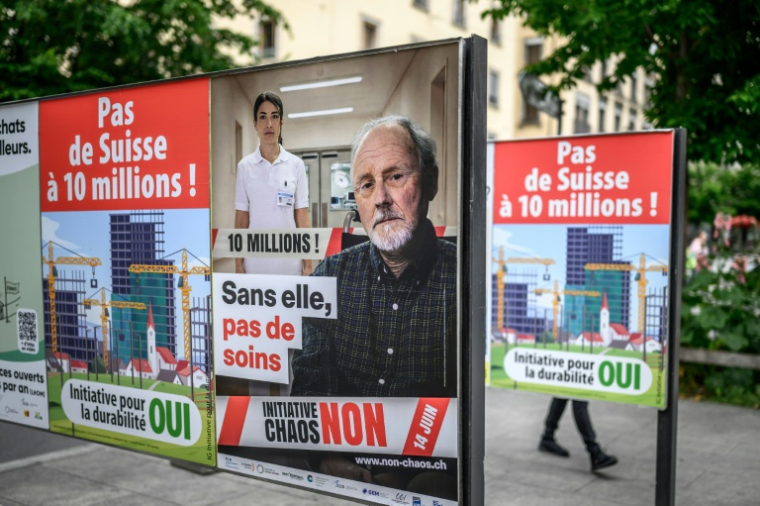Des panneaux mobilisant la population à s'opposer à une initiative anti-immigration, à Genève, le 4 juin 2026  ( AFP / Fabrice COFFRINI )