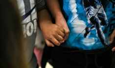 Deux enfants américains se tiennent le main à l'aéroport international de Miami avant de se rendre au Guatemala, le 4 décembre 2025  ( AFP / CHANDAN KHANNA )