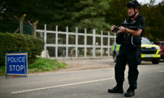 Un policier armé monte la garde devant la base de la RAF à Fairford, au lendemain de l'enquête ouverte par la police antiterroriste britannique, le 28 septembre 2026 dans le sud-ouest de l'Angleterre ( AFP / Ben STANSALL )