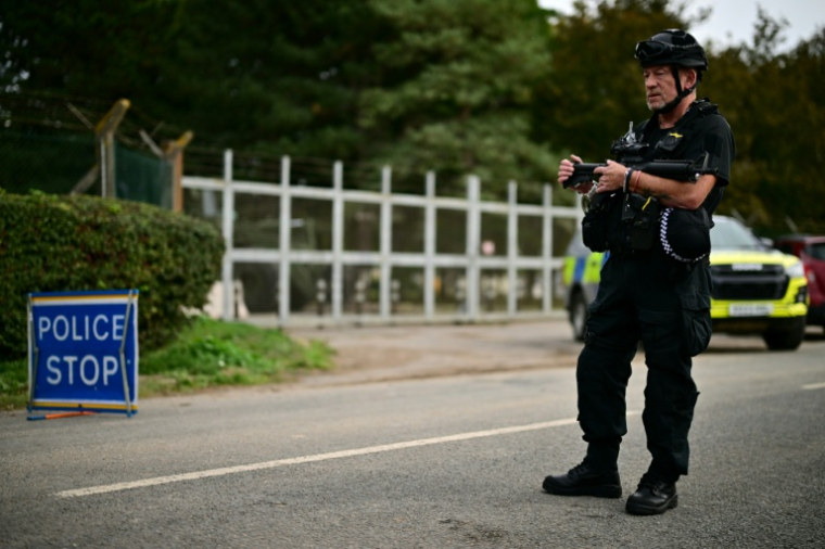Un policier armé monte la garde devant la base de la RAF à Fairford, au lendemain de l'enquête ouverte par la police antiterroriste britannique, le 28 septembre 2026 dans le sud-ouest de l'Angleterre ( AFP / Ben STANSALL )