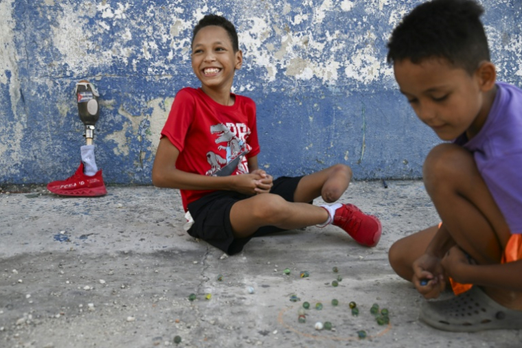 Juan Jose Guilarte, 10 ans, joue aux billes avec un camarade à La Havane, le 25 avril 2026 à Cuba ( AFP / YAMIL LAGE )