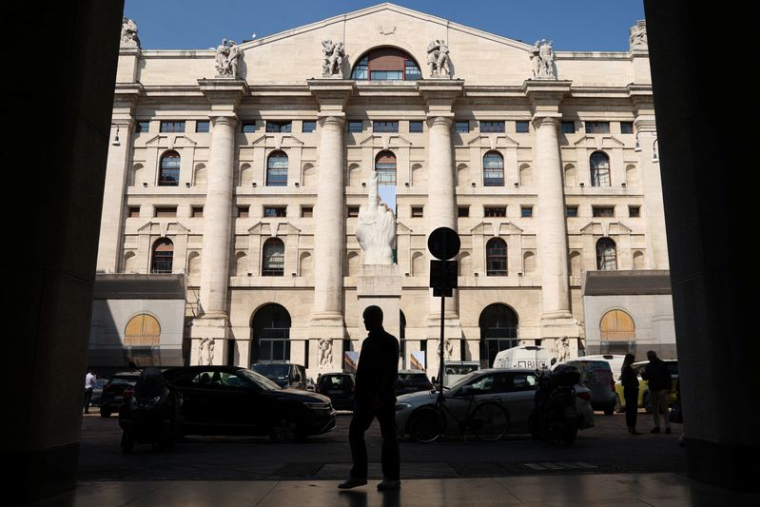 Une personne marche près de la Bourse de Milan (bourse italienne)