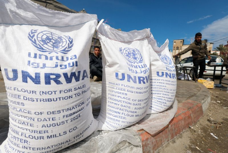 Des Palestiniens déplacés attendent de recevoir de l'aide de l'UNRWA, à Rafah