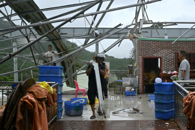 Des personnes nettoient l'intérieur d'un restaurant après le passage du super typhon Ragasa à Yangjiang, dans la province du Guangdong, dans le sud de la Chine, le 25 septembre 2025 ( AFP / ADEK BERRY )